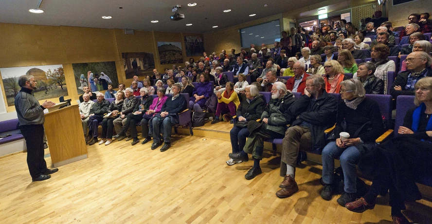 a woman speaks to a large group of people