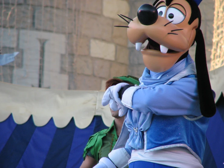 a goofy mouse character stands in front of a building