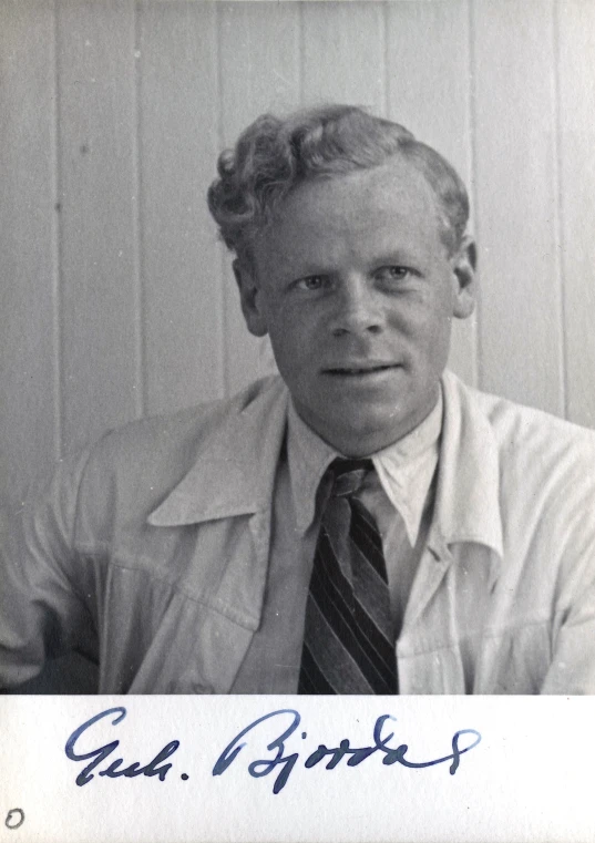 a man with white hair and a striped tie