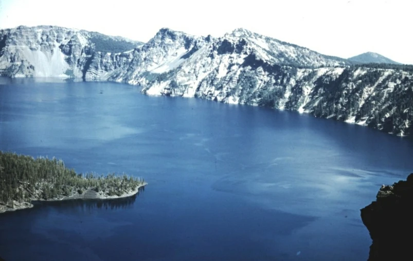 a snow - capped mountain overlooks a blue lake