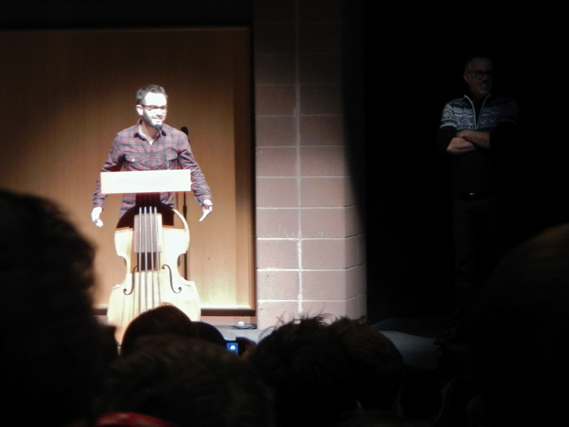 a man stands in front of a large screen giving a speech