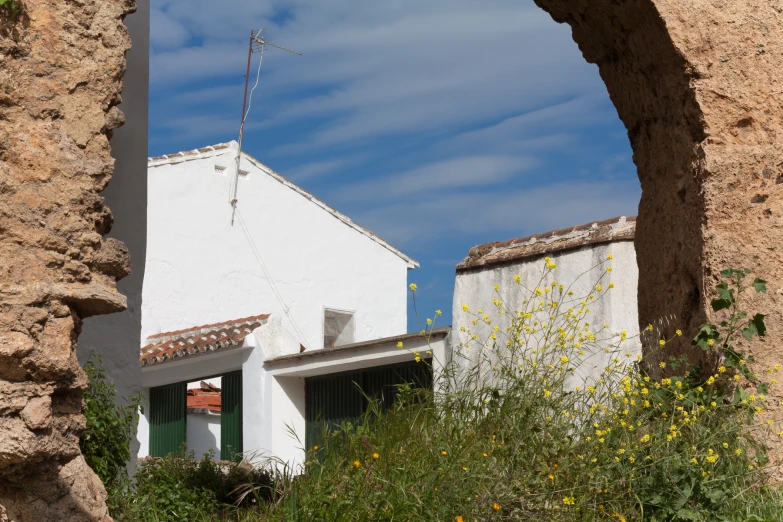 white stucco buildings against a blue sky and clouds