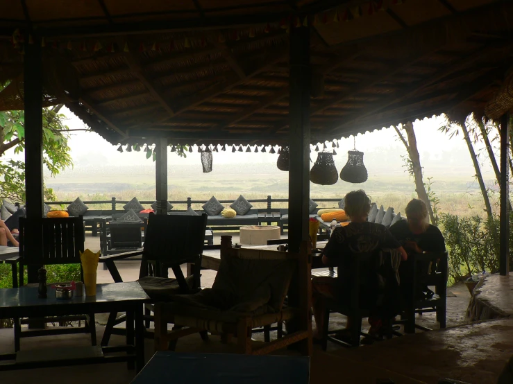 an outside dining area with lots of chairs and tables and some people eating