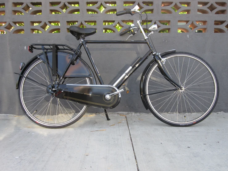 a bicycle parked next to a cement wall