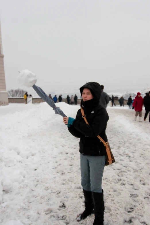 a woman is holding up an umbrella in the snow