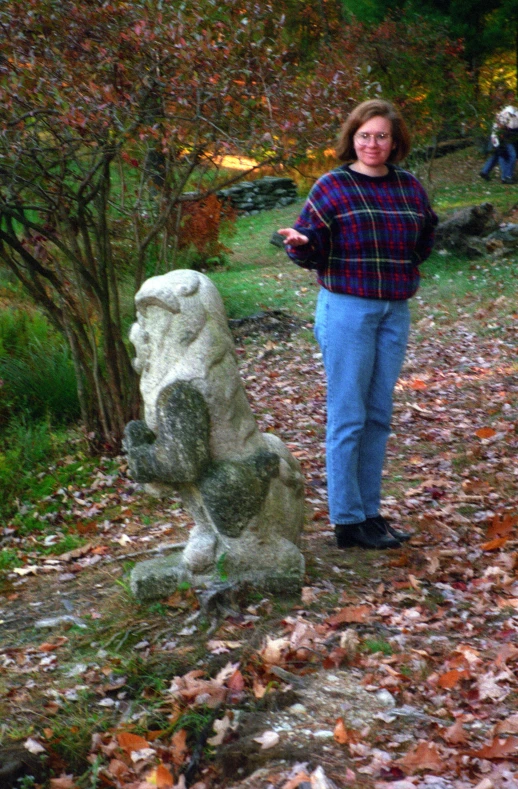 there is a woman standing in front of a rock