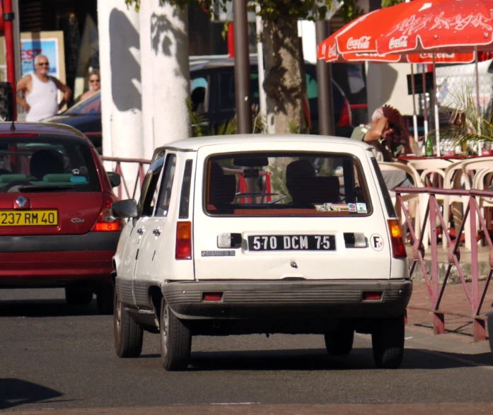 a car driving on a busy street next to a sidewalk