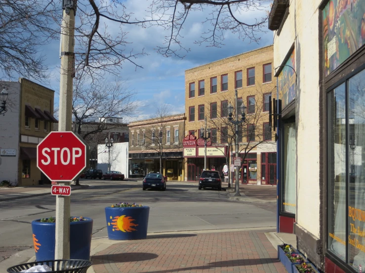 a red stop sign is in front of store fronts