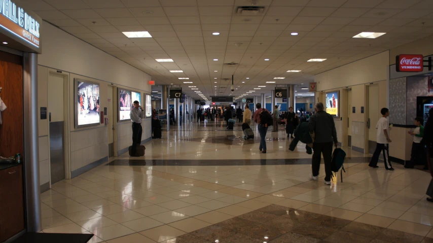 people walk through a large building with lights on