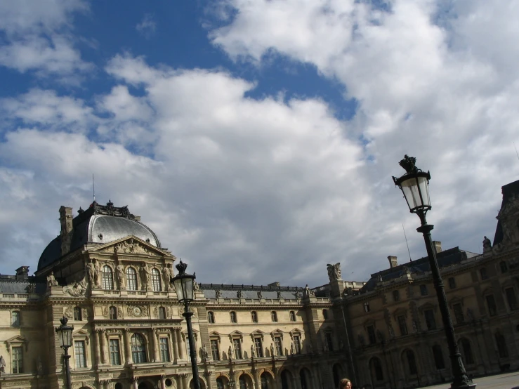 an old building with a tower and an ornamental iron pole