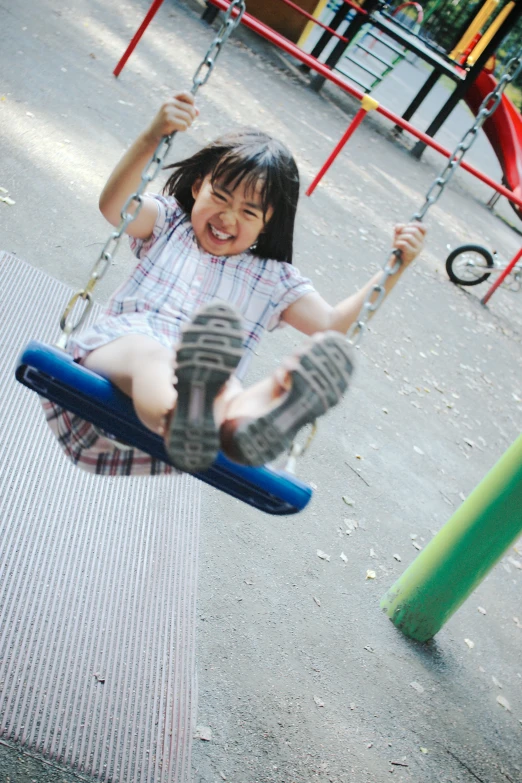 a young child sitting on top of a blue tire swing