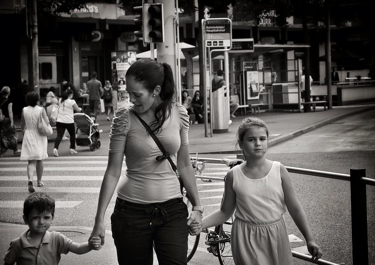 a woman and children crossing a street