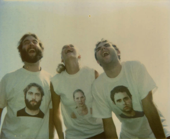 a group of four bearded men wearing t - shirts
