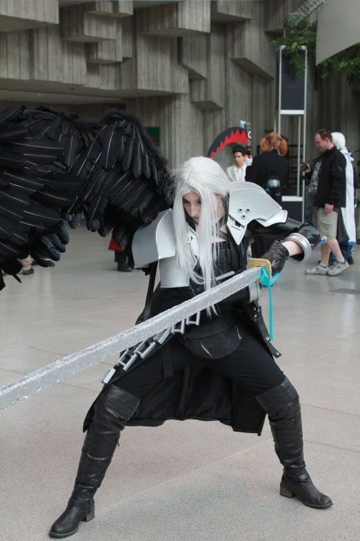 the cosplay dressed in black holds the sword in his hands