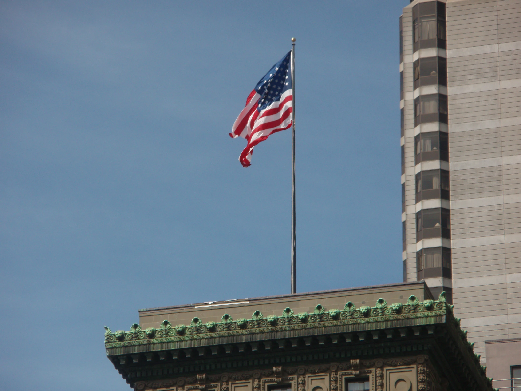 a view of a large american flag with a tall building in the background