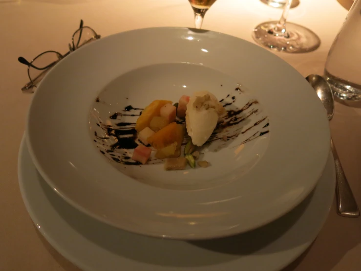 a desert on a white plate with a glass of wine in the background