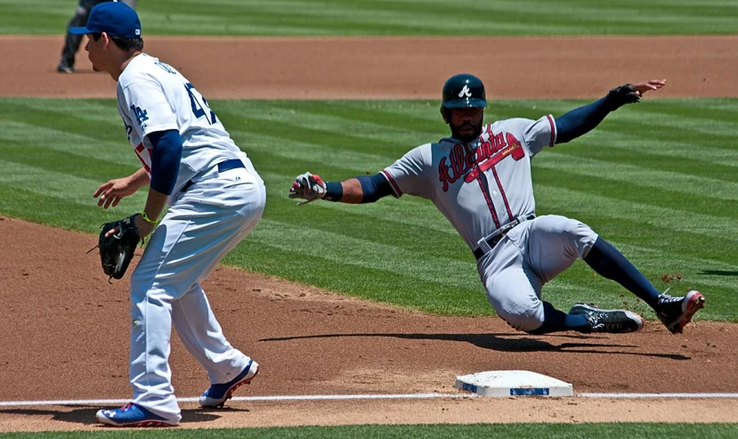 a baseball player sliding into base with the catcher
