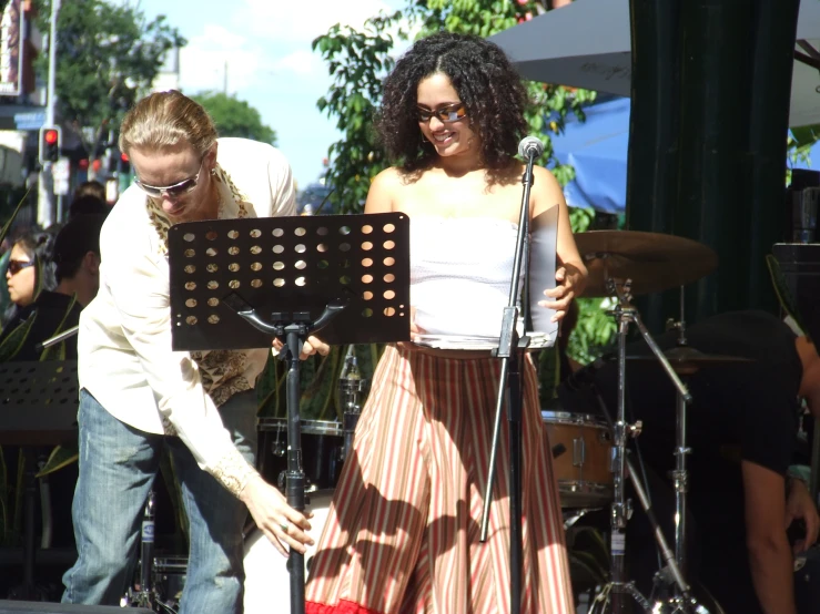 a man and a woman are standing in front of musical instruments