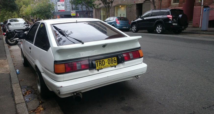 a car parked at a curb with a number plate on it