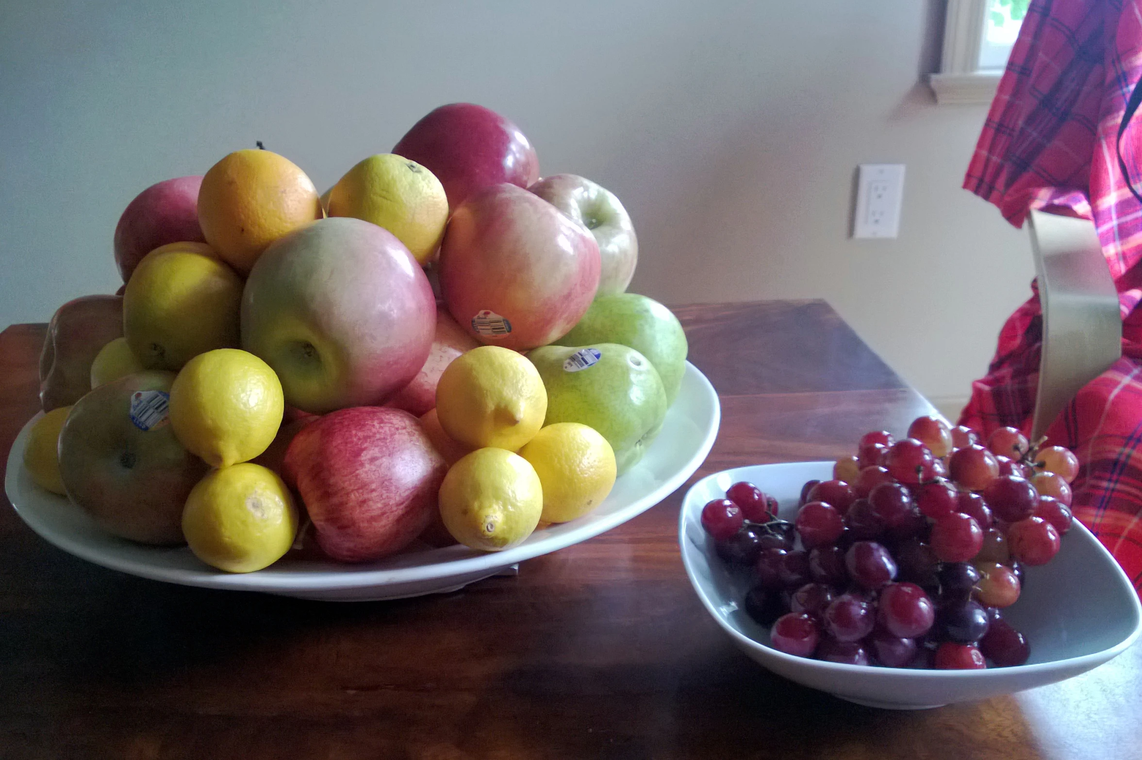 two bowls with apples, lemons and gs on the table