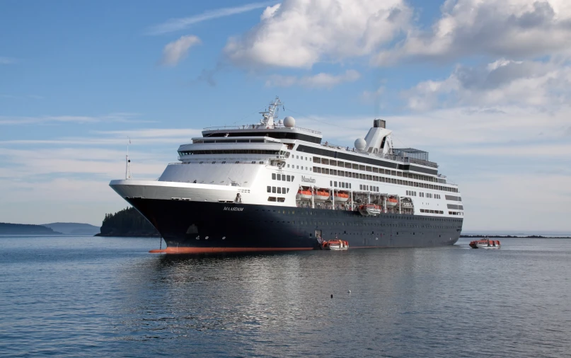 a large ship in the middle of water with a cloudy sky