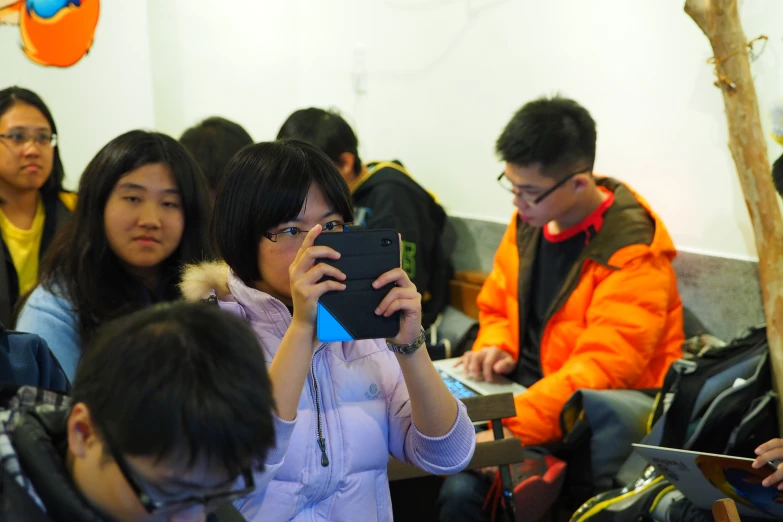 asian people in line at a table using their phones