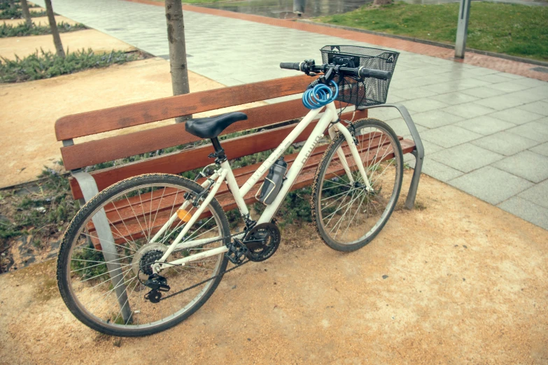 the bicycle is parked next to a bench on the side walk