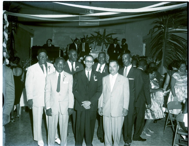 a group of people standing next to each other wearing suits