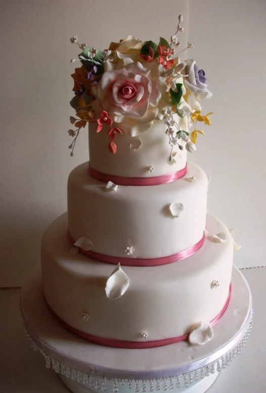 three layer wedding cake with flowers on top