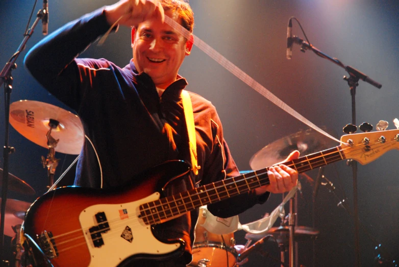 a man holding a guitar with a microphone in front of him