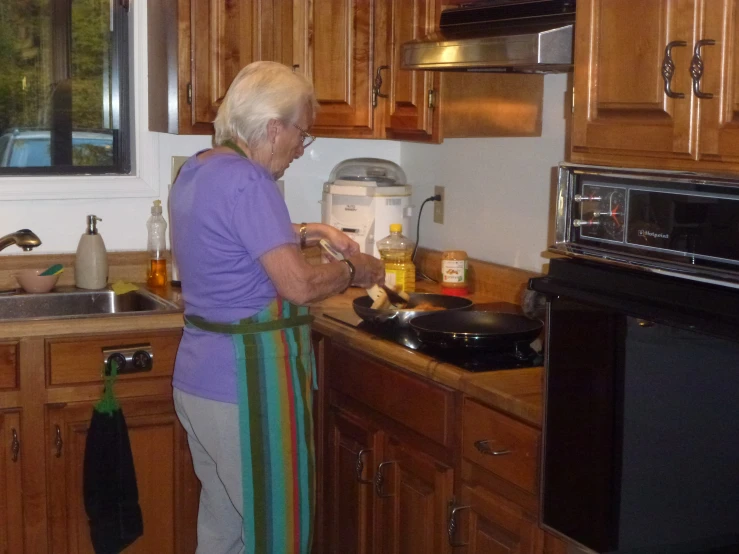 a woman in kitchen putting ingredients into an electric mixer