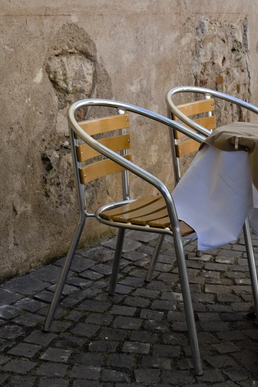 two chairs sitting next to a table with an umbrella on it