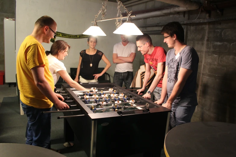 a group of people stand around a soccer board