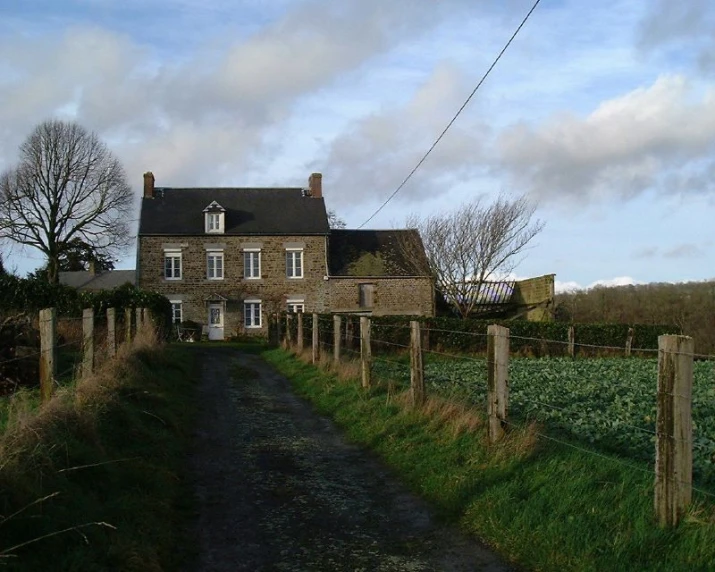 the old house is set next to a tall field