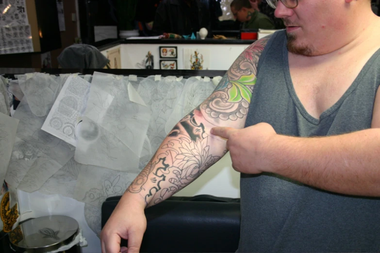 a man with a tattoo on his arm looking into the distance