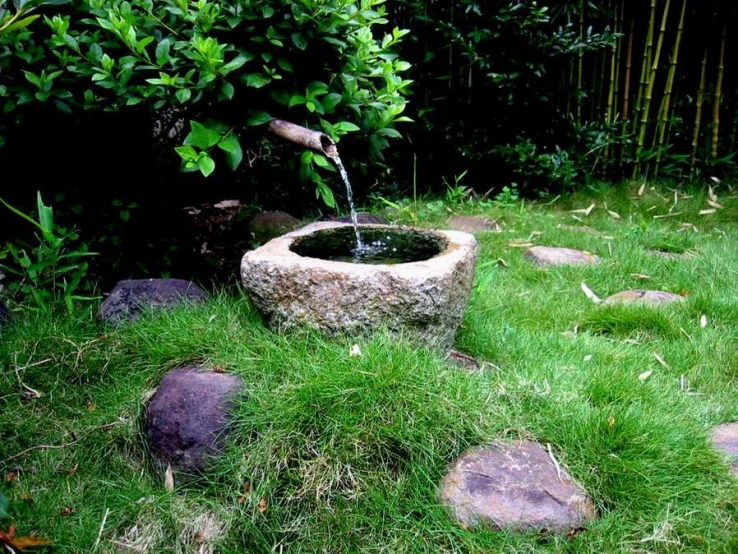 a fountain flowing into a small stone bowl