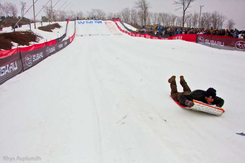 a man riding a snow board down the side of a slope