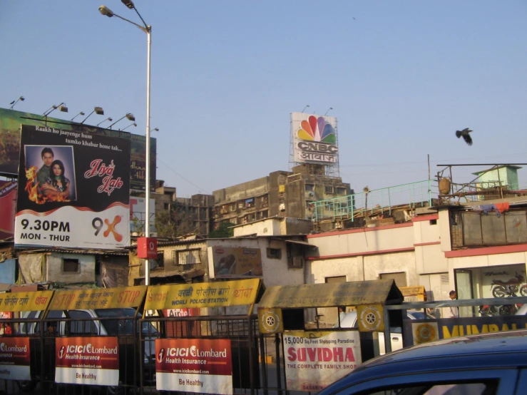 an empty street next to a tall building with lots of billboards