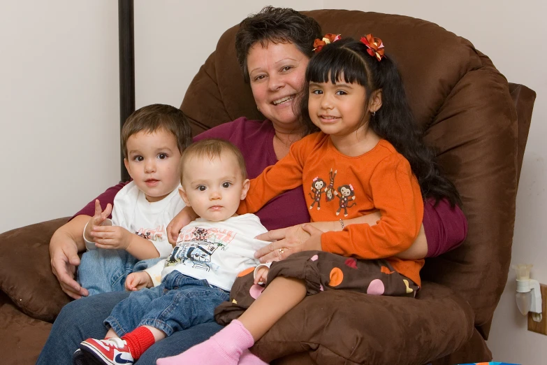 man and women with two children on brown couch