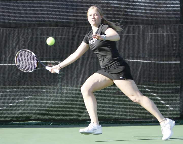 there is a young woman that is hitting the tennis ball