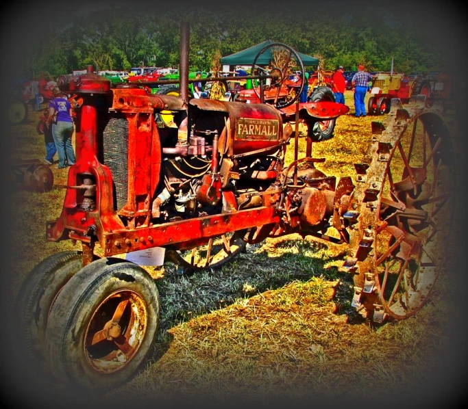 there is an old red tractor parked on grass