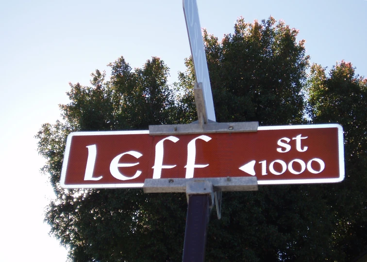 a red street sign sitting on the side of a tall pole