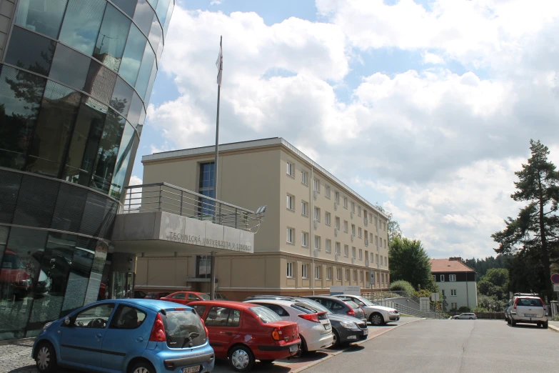 some parked cars outside a building and other buildings