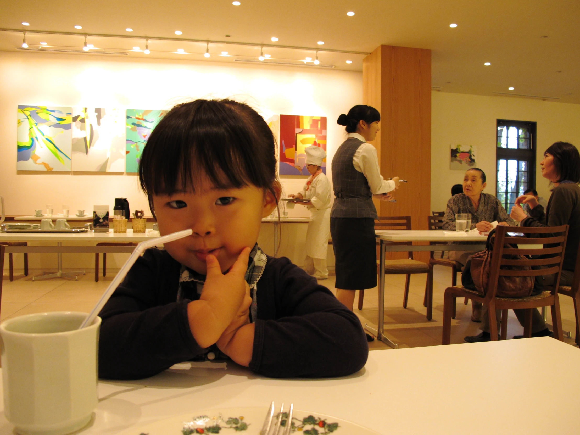 young asian boy at a dining table with a cup