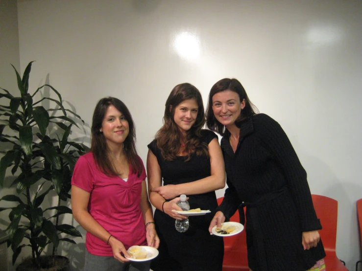 three woman pose together for the camera with plates in their hands