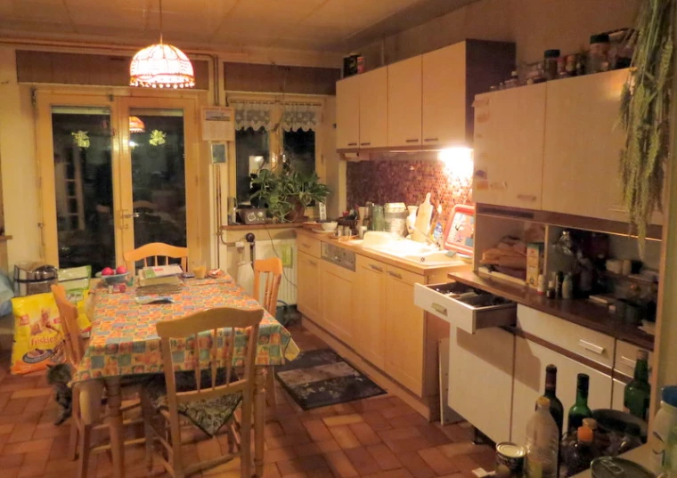 a kitchen that has a table with many chairs in it