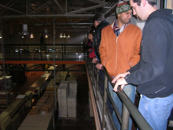 two men looking out the balcony of an indoor building