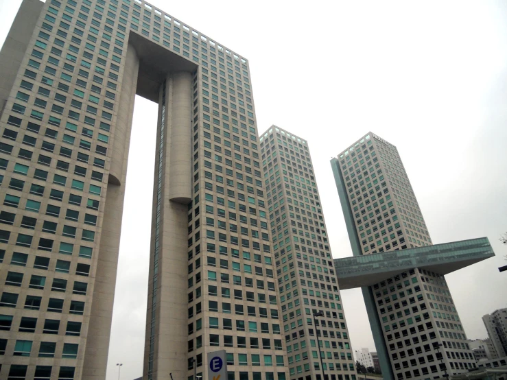 the large building has tall windows near two other buildings