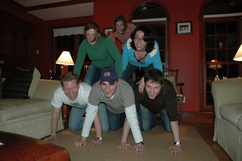 a group of people standing next to each other in front of a fireplace