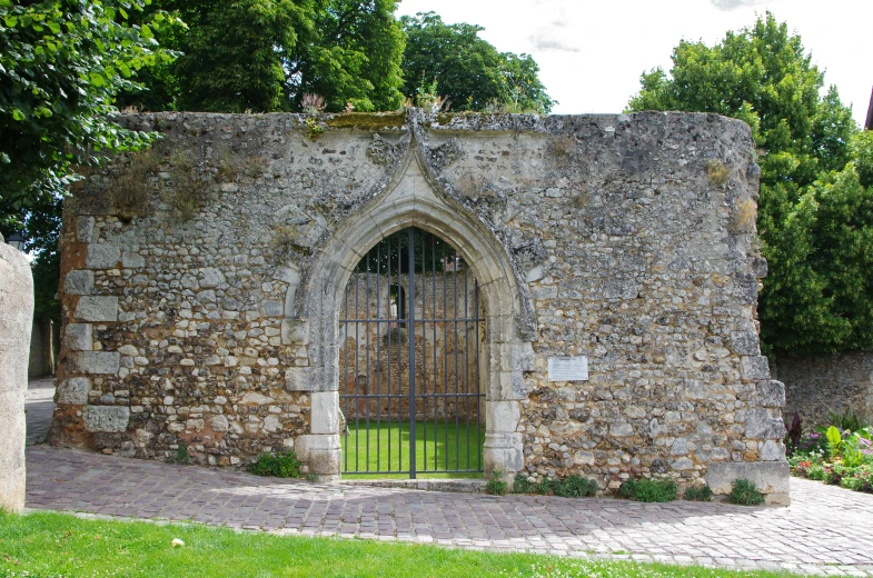 an arch door with a wrought iron fence around it